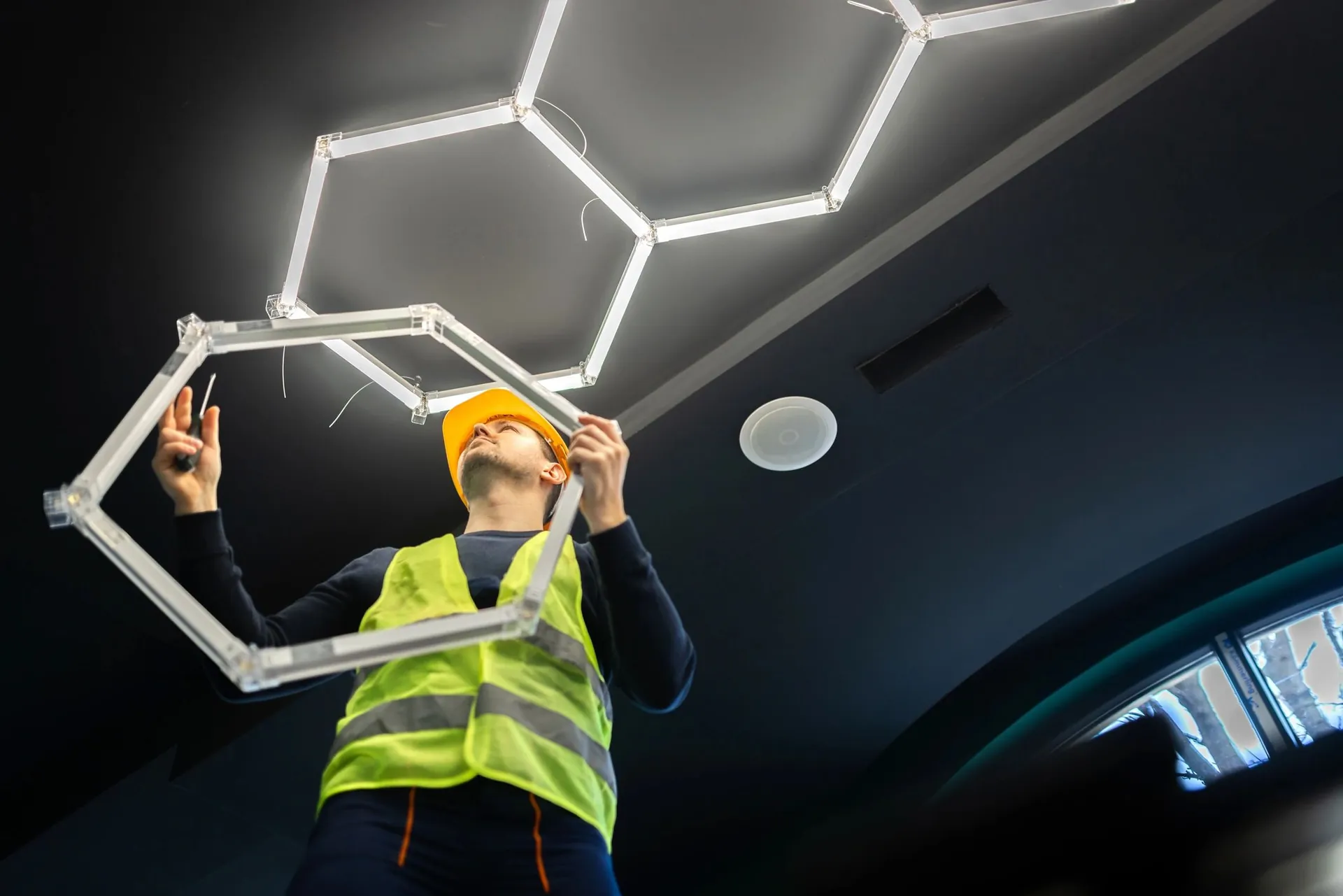 Technician installing an illuminated sign fixture